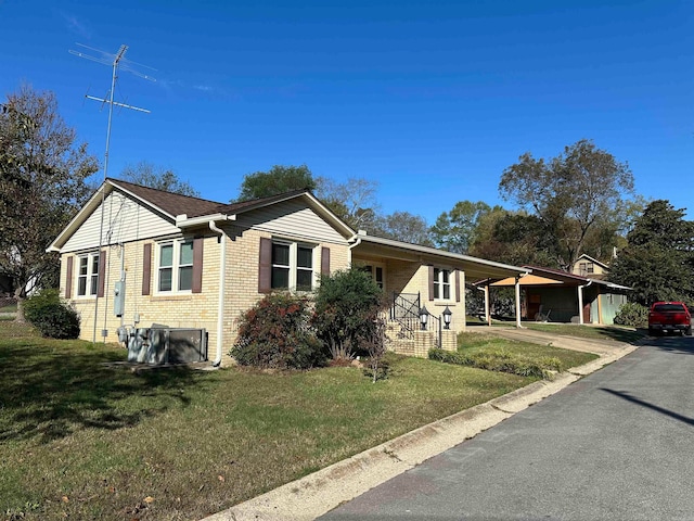 view of front of house with a carport and a front lawn