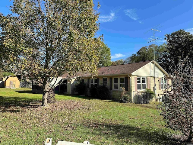 view of front facade with a storage unit and a front yard