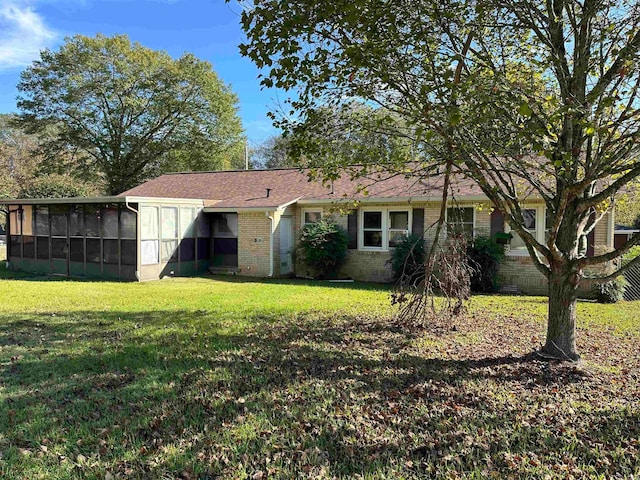 view of front of property featuring a sunroom and a front lawn