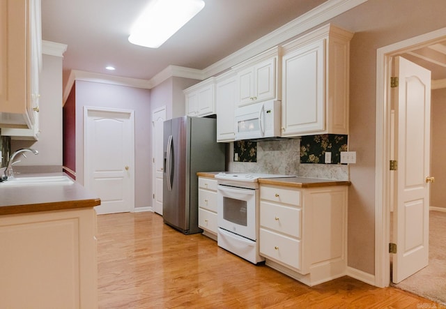 kitchen featuring backsplash, ornamental molding, white appliances, sink, and light hardwood / wood-style floors