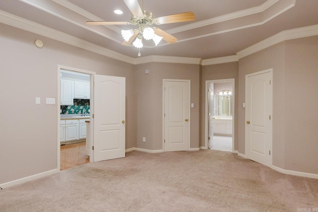 unfurnished bedroom with light colored carpet, ornamental molding, and ensuite bath