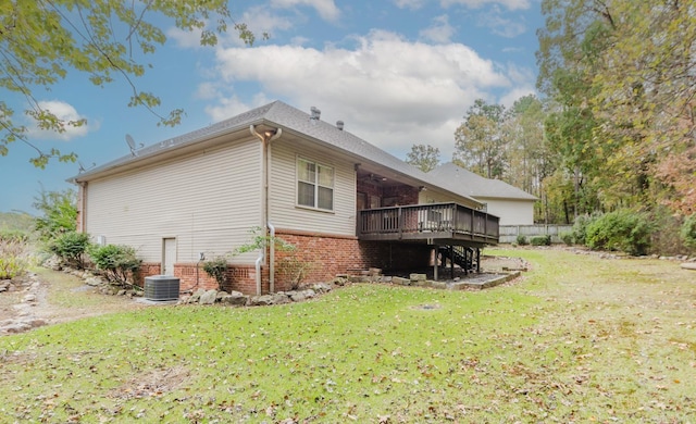 view of side of property featuring a deck, central AC unit, and a lawn