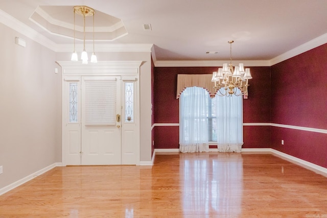 entryway with hardwood / wood-style floors, a chandelier, and ornamental molding