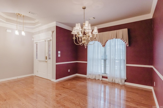 spare room with light hardwood / wood-style floors, crown molding, and a notable chandelier