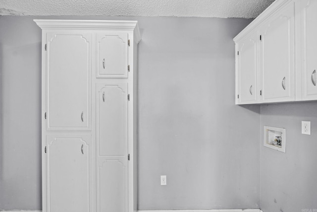 laundry room with cabinets, hookup for a washing machine, and a textured ceiling