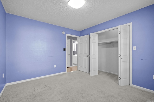 unfurnished bedroom with light carpet, a closet, and a textured ceiling