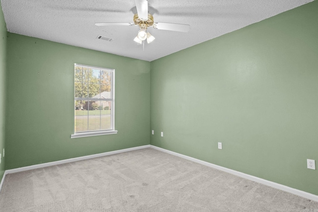 spare room featuring ceiling fan, carpet, and a textured ceiling