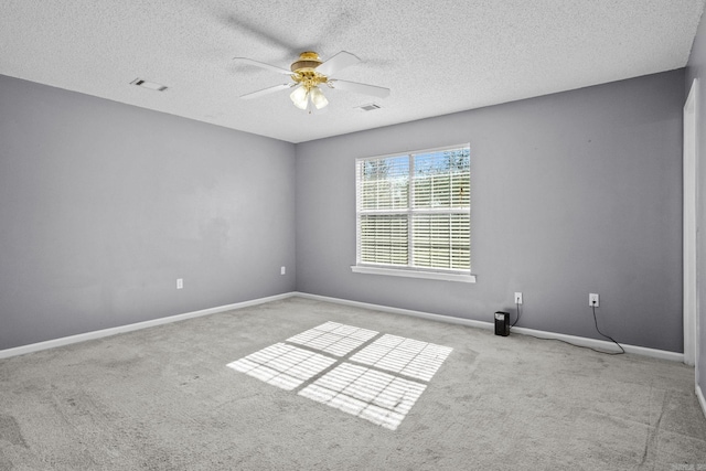 carpeted spare room with ceiling fan and a textured ceiling