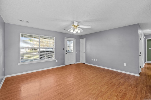 interior space featuring ceiling fan, light hardwood / wood-style floors, and a textured ceiling