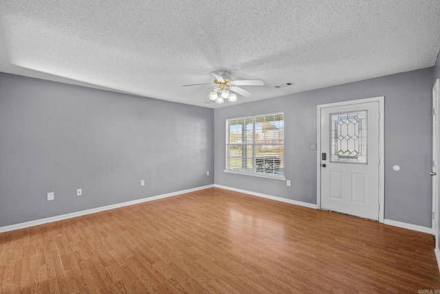 foyer entrance featuring hardwood / wood-style floors, ceiling fan, and a textured ceiling