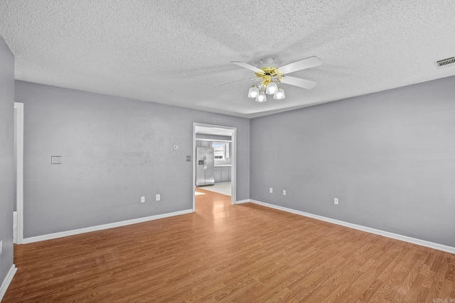 unfurnished room with ceiling fan, a textured ceiling, and light hardwood / wood-style flooring