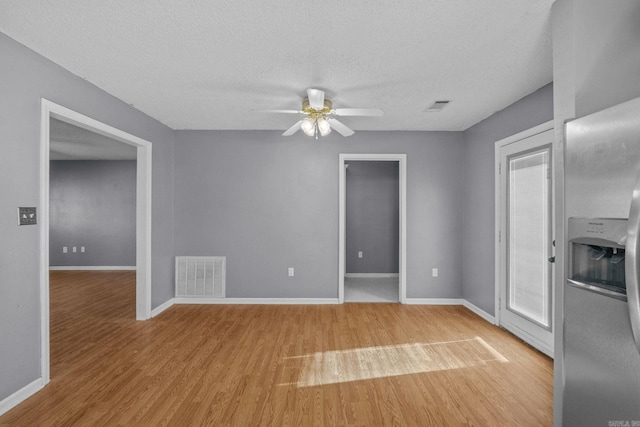 unfurnished living room featuring a textured ceiling, light hardwood / wood-style flooring, and ceiling fan