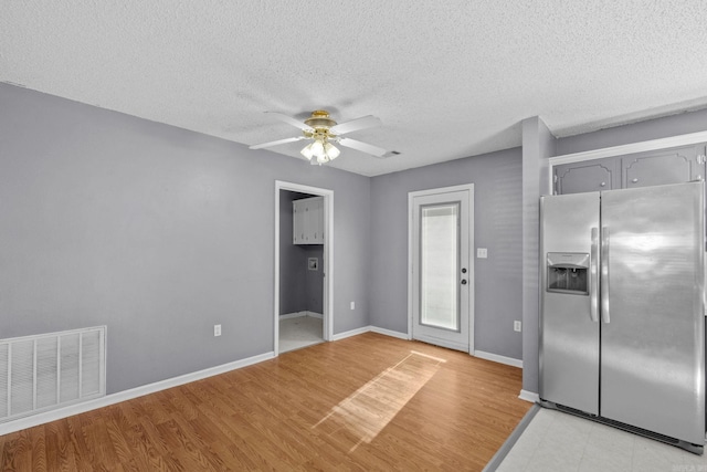 kitchen featuring gray cabinetry, stainless steel refrigerator with ice dispenser, ceiling fan, a textured ceiling, and light hardwood / wood-style floors