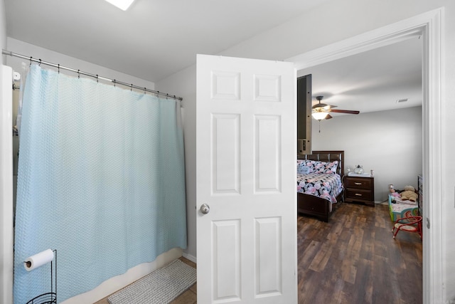 bathroom with hardwood / wood-style flooring, ceiling fan, and shower / bathtub combination with curtain