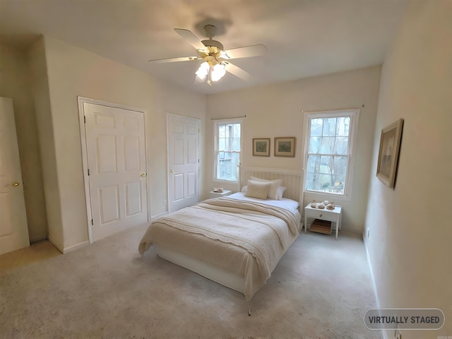 bedroom with ceiling fan and light carpet