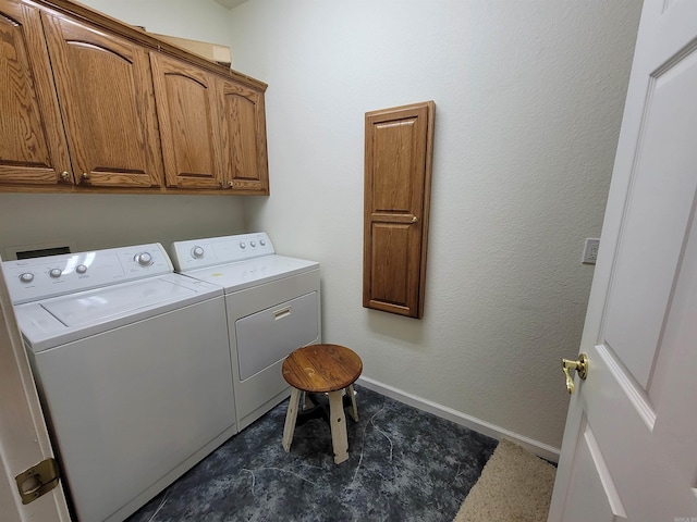 washroom with washer and dryer and cabinets