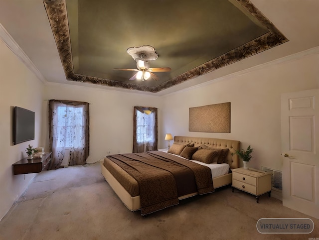 bedroom with carpet, a tray ceiling, and ceiling fan