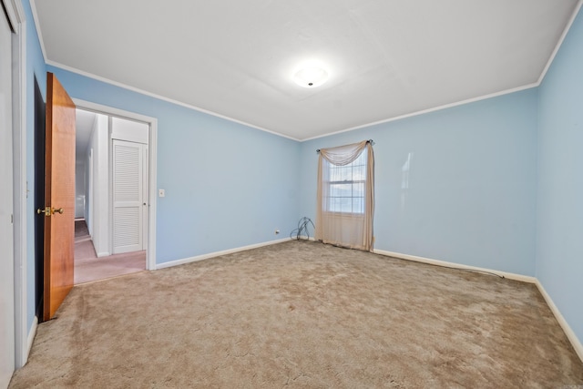 spare room featuring carpet and crown molding