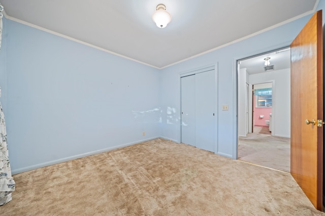 unfurnished bedroom featuring a closet, carpet floors, and ornamental molding