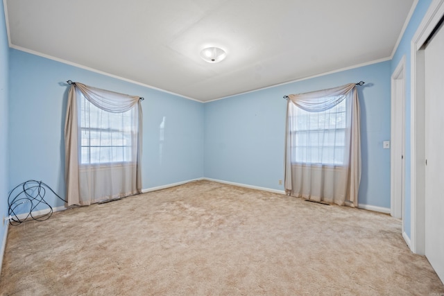 unfurnished room featuring a healthy amount of sunlight, crown molding, and light carpet