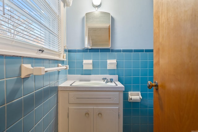 bathroom with vanity and tile walls