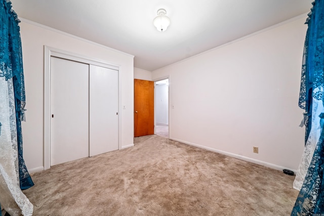 unfurnished bedroom featuring light colored carpet, ornamental molding, and a closet