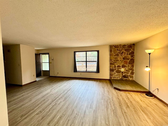 unfurnished room with hardwood / wood-style floors and a textured ceiling