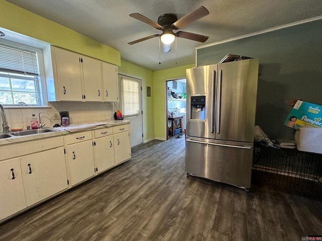 kitchen featuring backsplash, dark wood-type flooring, sink, stainless steel refrigerator with ice dispenser, and white cabinetry