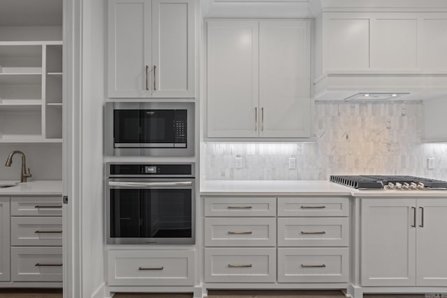 kitchen featuring appliances with stainless steel finishes, backsplash, and white cabinetry