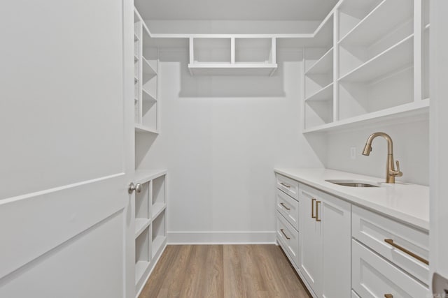 walk in closet featuring sink and light hardwood / wood-style flooring