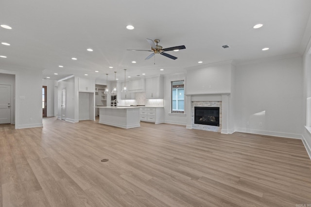 unfurnished living room featuring ceiling fan, light hardwood / wood-style floors, and crown molding