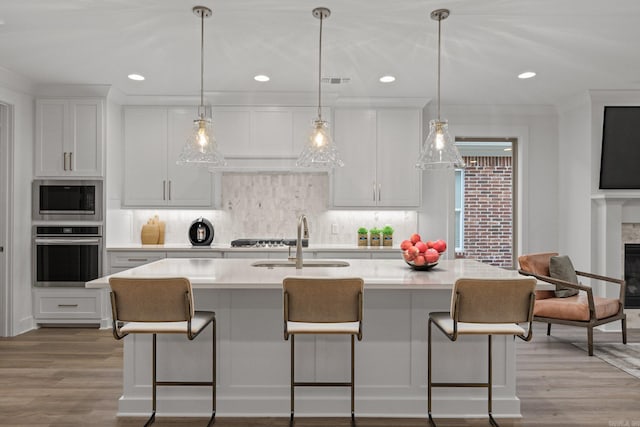 kitchen with white cabinetry, light hardwood / wood-style flooring, and stainless steel appliances