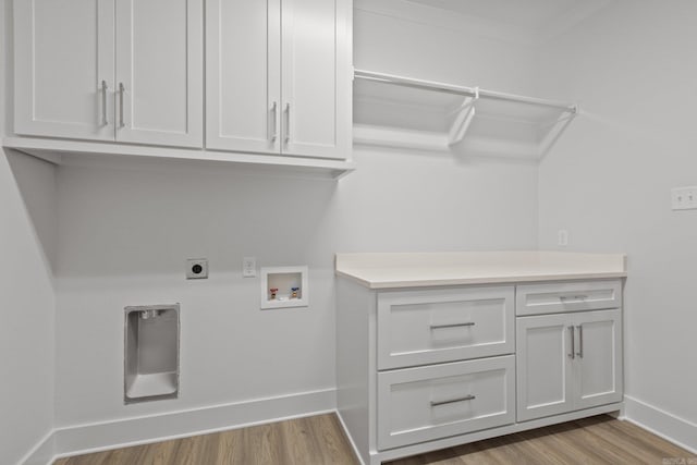 clothes washing area featuring cabinets, washer hookup, light wood-type flooring, and crown molding