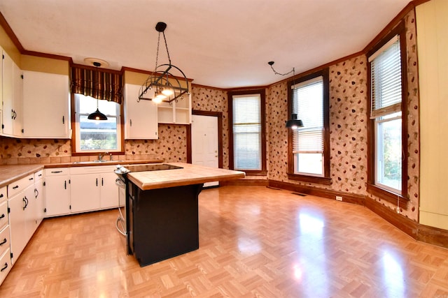 kitchen with tile countertops, light parquet floors, decorative light fixtures, a kitchen island, and white cabinetry