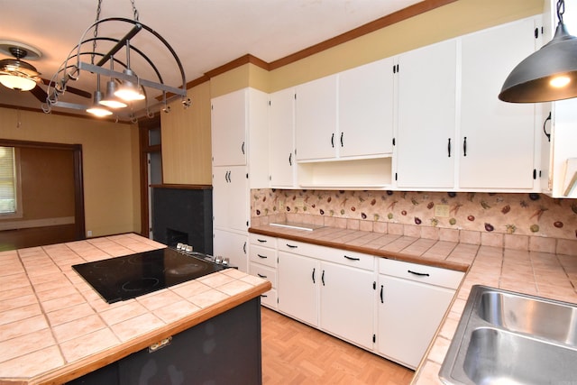 kitchen featuring tile countertops, decorative light fixtures, and white cabinetry