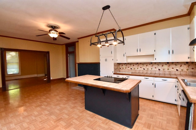 kitchen featuring white cabinetry, a center island, tile countertops, decorative light fixtures, and black electric cooktop