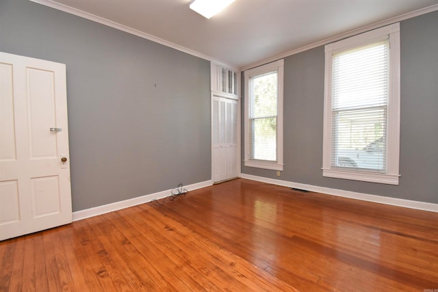 unfurnished room with wood-type flooring and ornamental molding