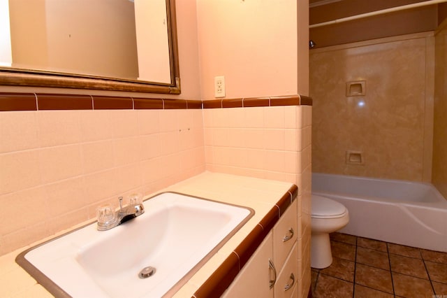 full bathroom with tiled shower / bath combo, tile patterned flooring, toilet, vanity, and tile walls