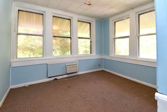 unfurnished room featuring an AC wall unit and dark colored carpet