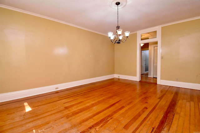 unfurnished room with wood-type flooring, an inviting chandelier, and ornamental molding