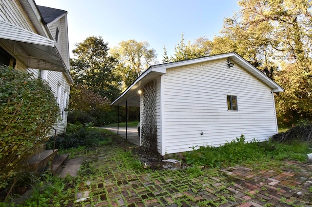 view of property exterior with a patio area and a carport