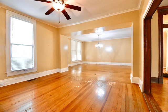 empty room featuring light hardwood / wood-style flooring, ceiling fan with notable chandelier, and ornamental molding