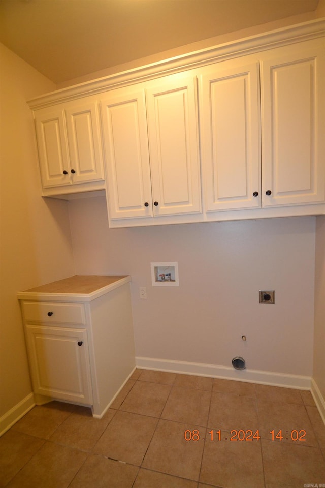 laundry room featuring cabinets, washer hookup, hookup for an electric dryer, gas dryer hookup, and light tile patterned flooring