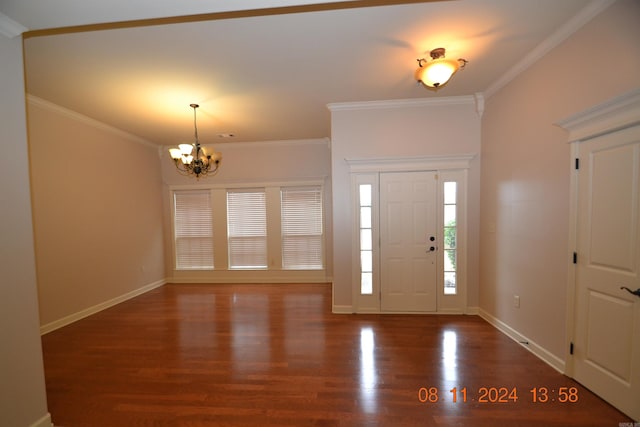 entrance foyer with dark hardwood / wood-style flooring, crown molding, and a notable chandelier