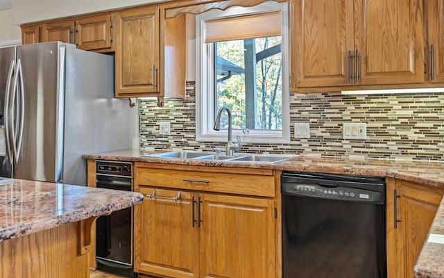 kitchen with decorative backsplash, stainless steel refrigerator with ice dispenser, light stone counters, sink, and black dishwasher