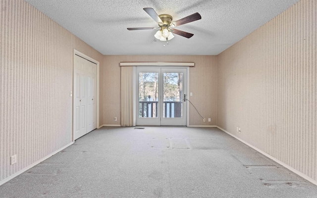 carpeted spare room featuring a textured ceiling and ceiling fan