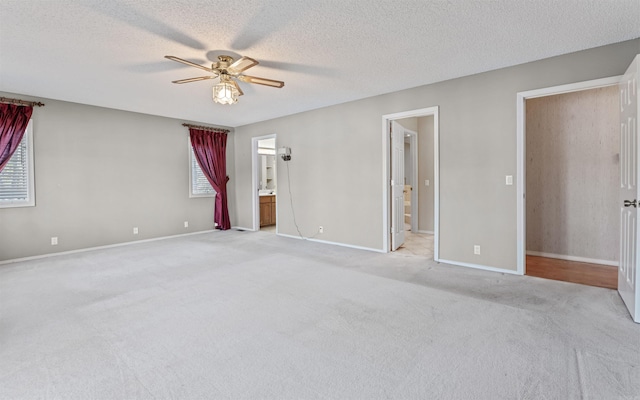 interior space featuring ensuite bath, ceiling fan, and multiple windows