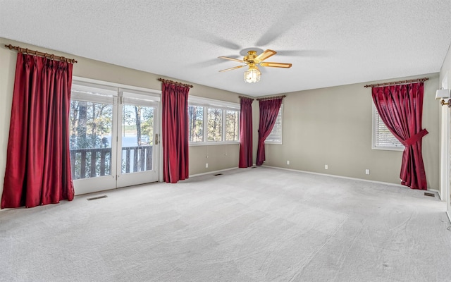 carpeted empty room featuring a textured ceiling and ceiling fan