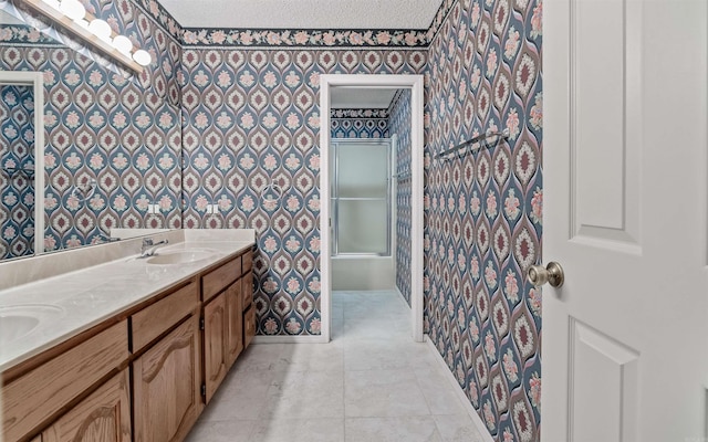 bathroom with tile patterned flooring, vanity, and a textured ceiling