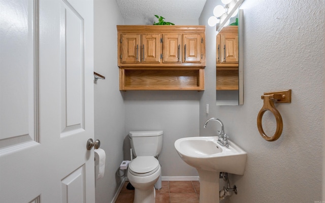 bathroom with tile patterned floors, a textured ceiling, and toilet